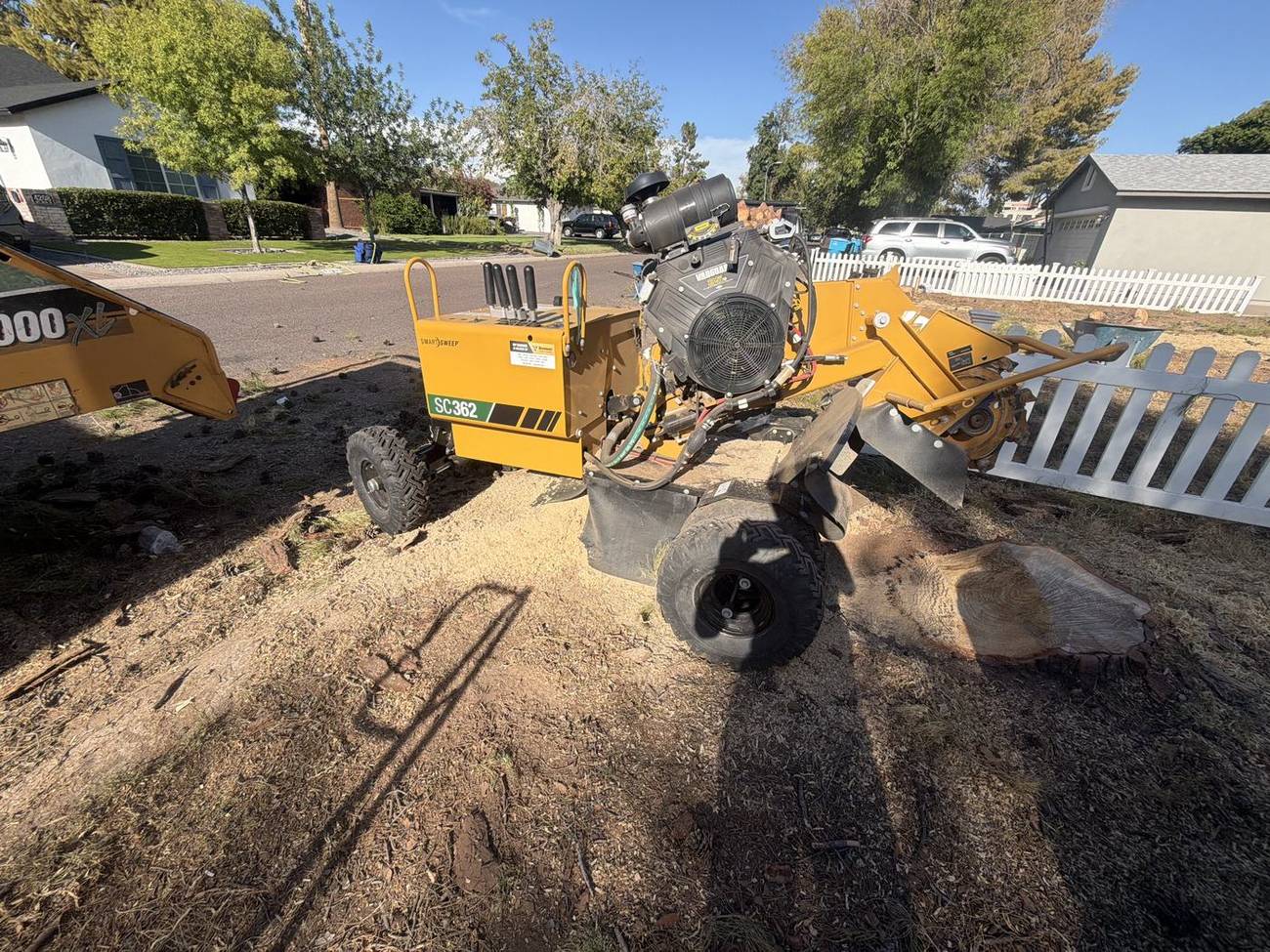 Stump grinder working on a large stump in a Phoenix front yard